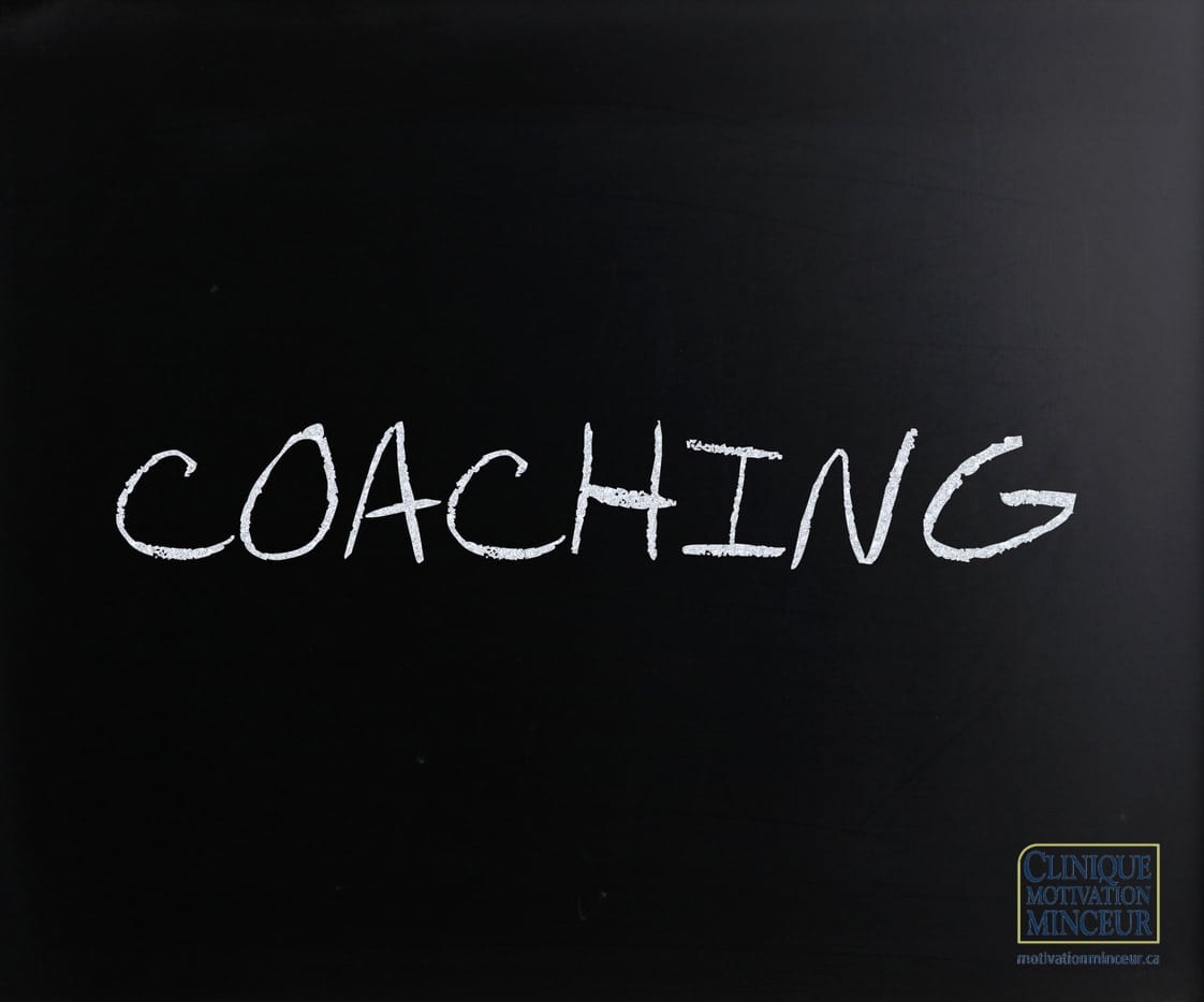 "Coaching" handwritten with white chalk on a blackboard "Coaching" handwritten with white chalk on a blackboard